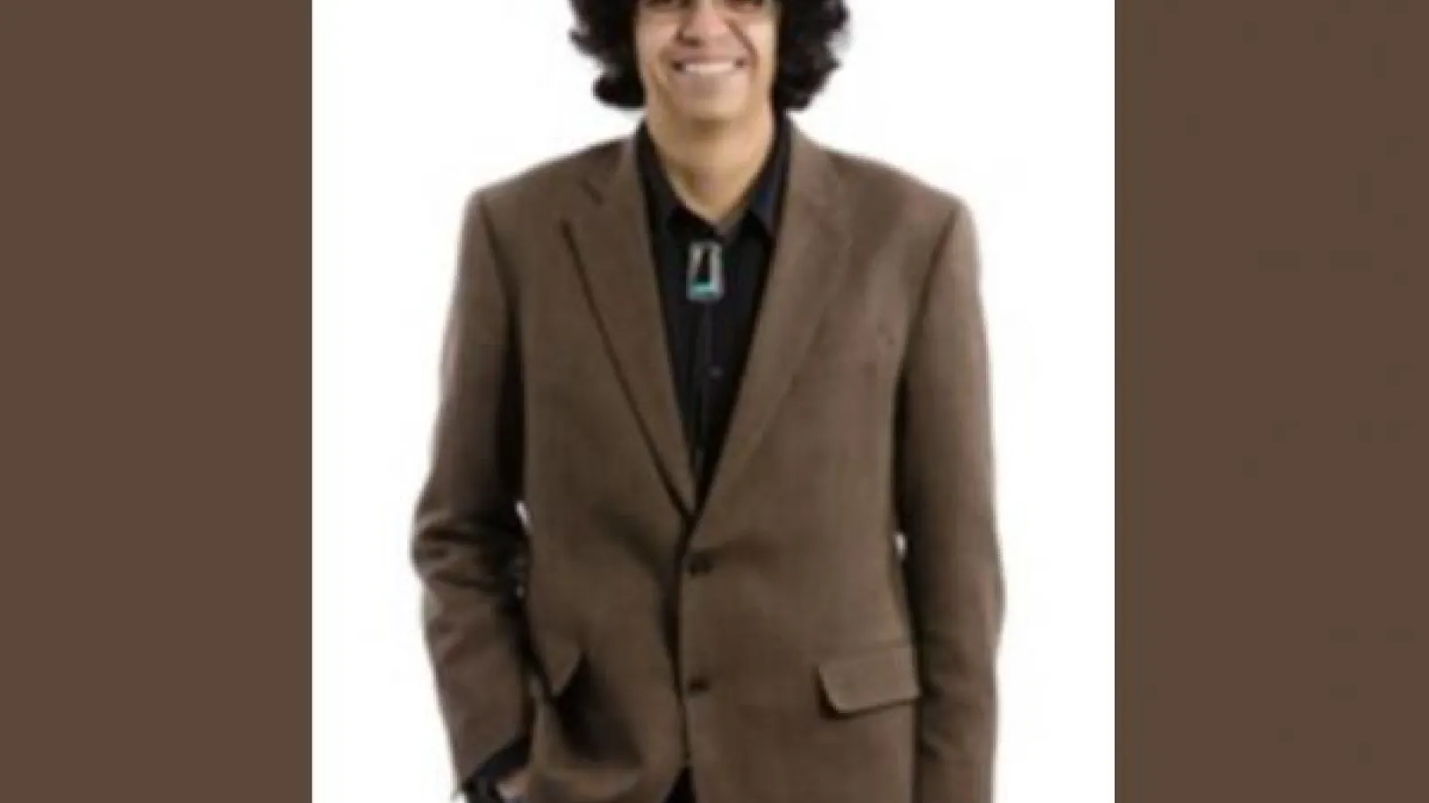 Gregorio Gonzales wearing a brown suit with a black shirt.