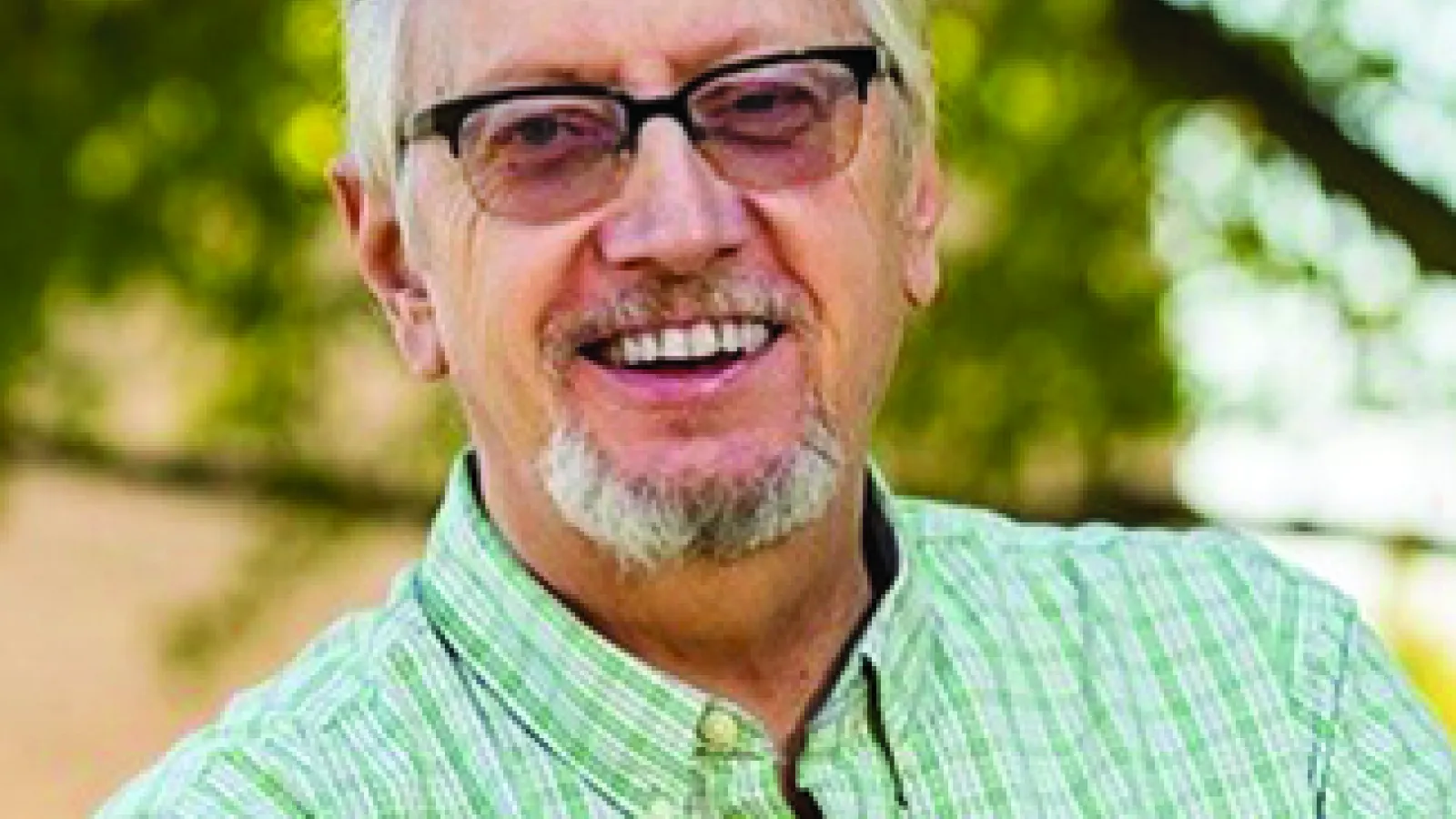 John Low wearing a green and white checkered shirt and a pair of glasses.