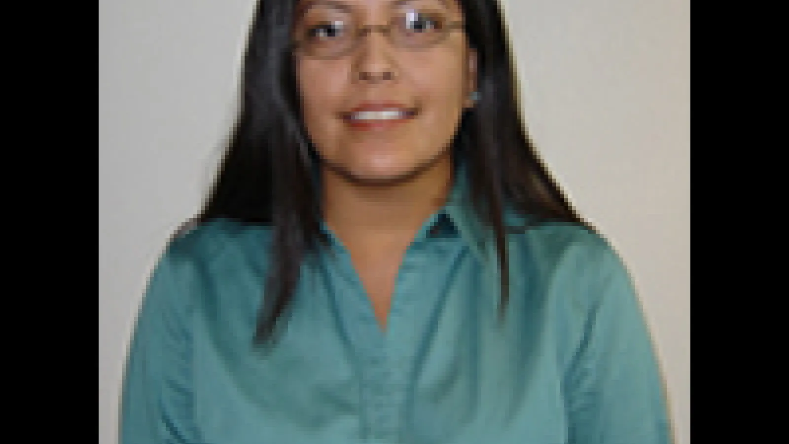 Shanna Ketchum Heap of Birds, a woman with brown skin, black hair, and a blue shirt looks directly at the camera