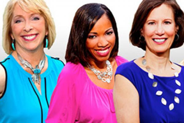 Three women smiling and looking at the camera against a white background